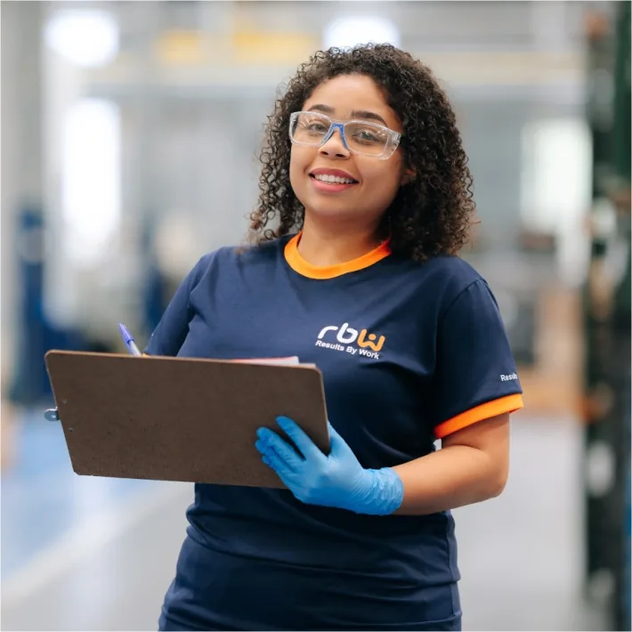 Colaboradora RBW Grupo com prancheta realizando controle de qualidade industrial