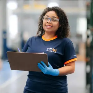 Colaboradora RBW Grupo com prancheta realizando controle de qualidade industrial